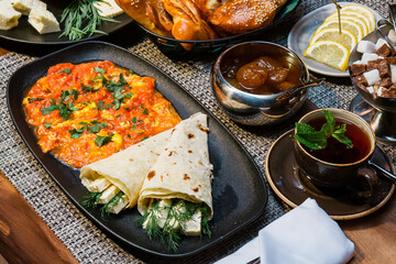 Appetizing breakfast in a restaurant with cheese, herbs and stewed vegetables
