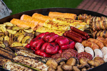 Healthy street food to go - potatoes, mushrooms, eggplants, meats, bell peppers, and red tomatoes.Delicious food cooked over an open fire, which is offered at a street food fair, event, festival.