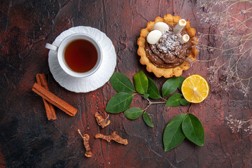 top view cup of tea with delicious little cake on dark background cookie dessert biscuits
