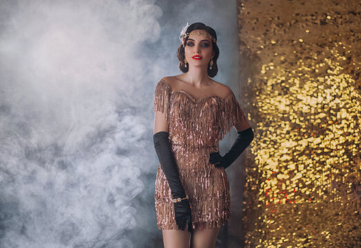 Beauty happy young flapper woman sexy retro lady. golden headband, finger wave hairstyle, vintage style 20s dress evening makeup bright lips. Backdrop room full smoke. Elegant trendy image for party