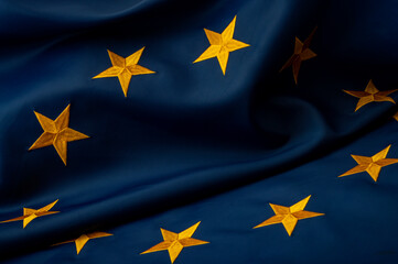 International collaboration, political unity and economic partnership concept European Union flag with yellow stars on blue background with dramatic lighting