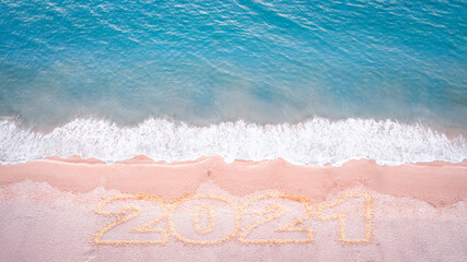 Fototapeta na wymiar Aerial drone top view happy new year 2021 written on sandy beach sea with copy space. New year concept