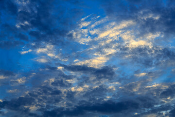 A blue sky with an abstract pattern of small light and dark clouds