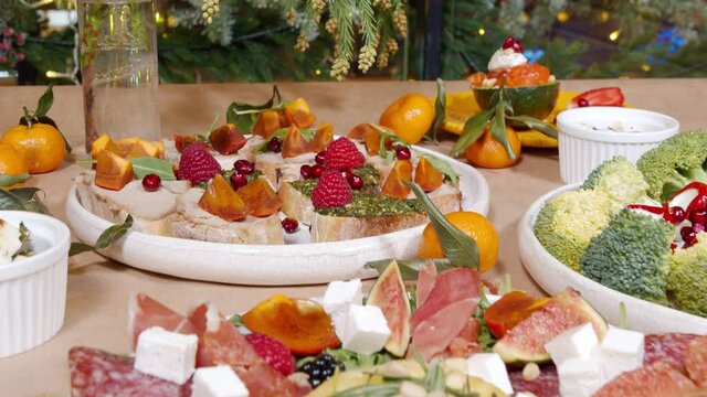 Festive table with delicious appetizers with cheese, prosciutto, fresh fruits and berries. Healthy eating. Background.