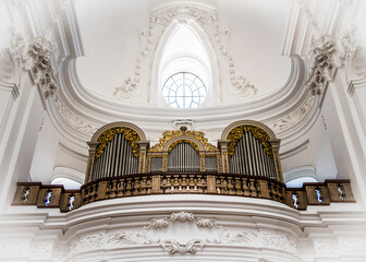 A musical organ in a fabulous white interior of a baroque church of Kollegienkirche (Collegiate...