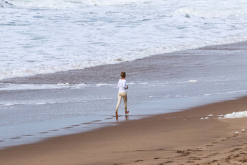 Girl running on the beach by the sea