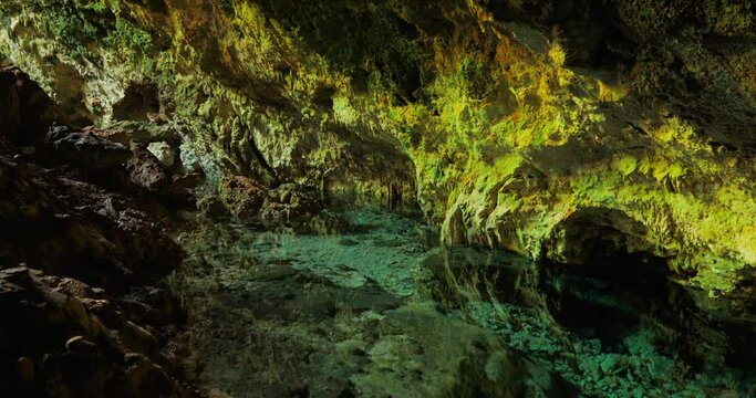 Frame in the movement of the grotto. A beautiful video of a cave that is underground where you can see the rocks that hang over the lake with water.