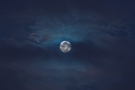 Full moon among the clouds in a blue night sky of Lima Peru