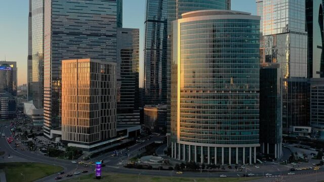 Moscow city glass skyscrapers drone zoom in close to the buildings, sun reflection in the windows. Moscow International Business Center at the sunset, evening