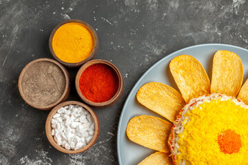 top close view of salad on the right bottom side with herbs on side centered on dark grey table