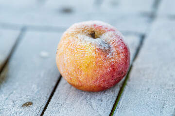 Frosted apple on a wooden table