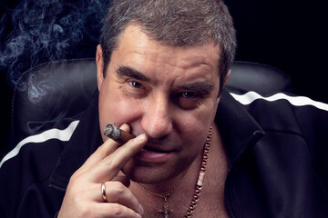 mobster-a cigar-smoking male criminal looks angrily at the camera and grins