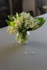 bouquet of white lilies of the valley in a glass vase