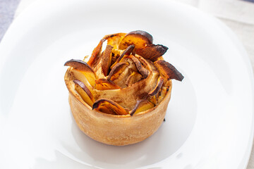 Handmade cinnamon and apple buns on a white plate.