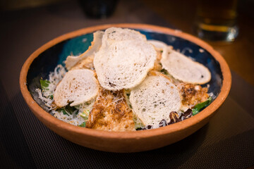 Chicken, greens, tomatoes and bread salad in a beautiful plate