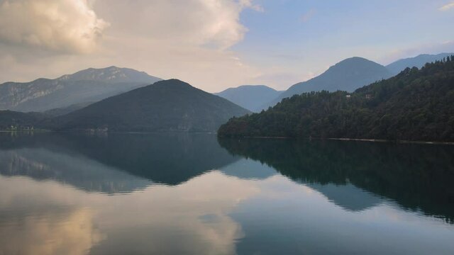 Flying over turquoise water of Lake Ledro. Stunning Italian Alpine landscape