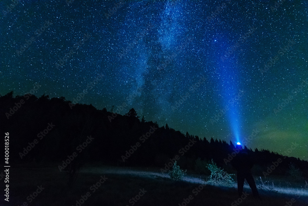 Wall mural fantastic starry night with galaxy milky way with a tourist and a tent on the mountain range in the 