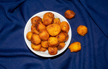 Sugar palm fritters or taler bora in a white bowl on blue cloth texture background.