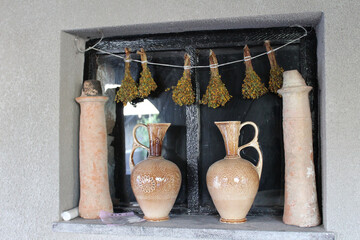 Closeup shot of beautiful wooden jugs with patterns with stone decorations and herbs