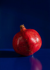 Red pomegranate on blue background