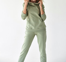 girl wears light green hoodie and pants. studio shot for sport clothing sale