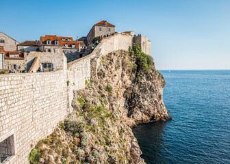 Naklejka premium View of the medieval city wall on a rock in the Adriatic sea near the city of Dubrovnik