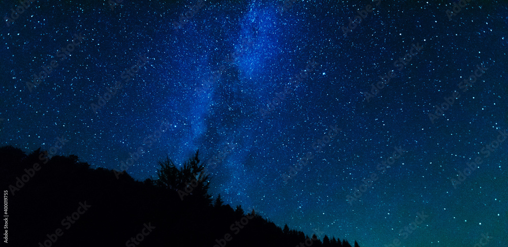 Wall mural fantastic starry night with galaxy milky way with a tourist and a tent on the mountain range in the 
