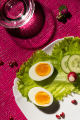 Still life with healthy food: salad, cucumber, boiled egg, water