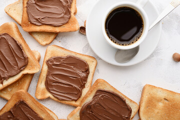Lots of bread toast spread with chocolate-nut paste and a cup of coffee