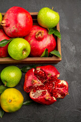 top view fresh pomegranates with tangerines and apples on a dark background ripe color fruit