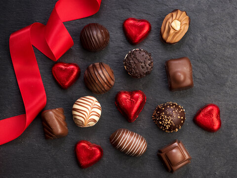 Chocolate candy with red ribbon, top view, flat lay