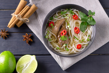 Pho Bo - Vietnamese fresh rice noodle soup with beef, herbs, lime and chili. Vietnamese national dish. Top view.