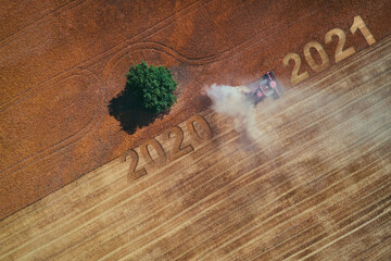 2021 Happy new year concept of aerial view on the combine working on the large wheat field