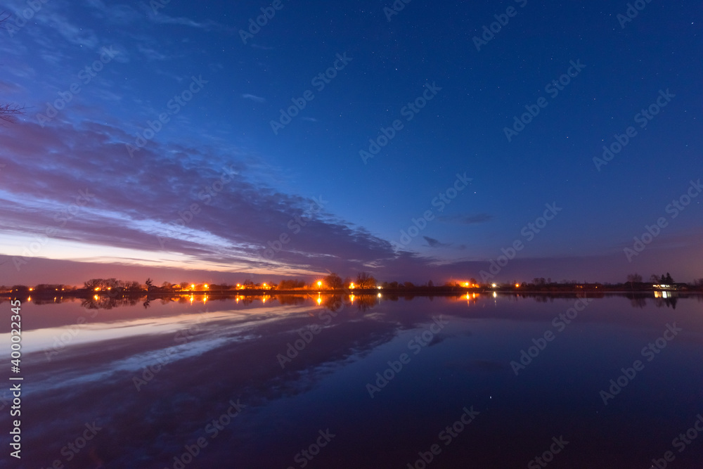 Wall mural a magical starry night on the river bank with a large tree and a milky way in the sky and falling st