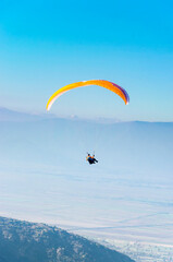 paraglider in flight in blue sky