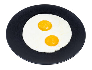 two fried eggs on black plate isolated on white background