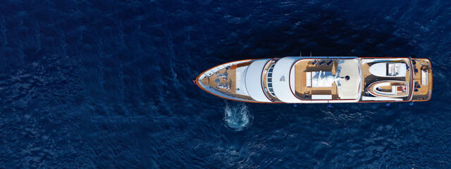 Aerial drone ultra wide photo of luxury yacht with wooden deck anchored in Mediterranean deep blue...