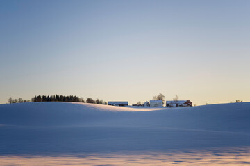 farm in the snow at sunset