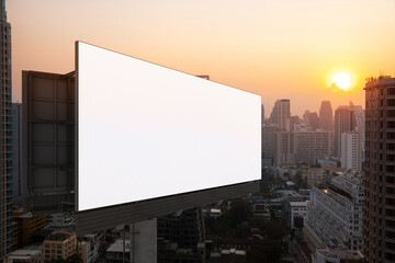Blank white road billboard with Bangkok cityscape background at sunset. Street advertising poster, mock up, 3D rendering. Side view. The concept of marketing communication to promote or sell idea.
