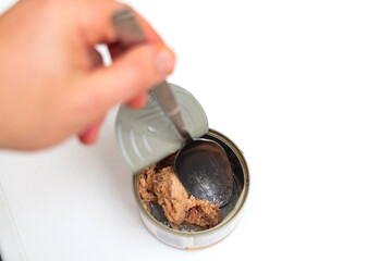 Tuna in an open tin can on a white background. Eat fish from a can.