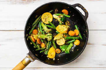 Various fried vegetables in a pan. Mix of carrots, green beans, cauliflower.