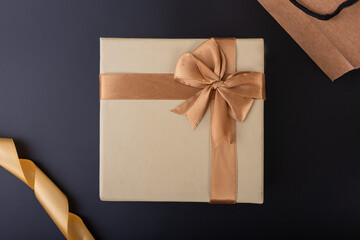 gift box with golden ribbon on black background flat lay top shot