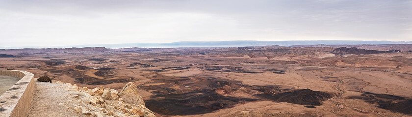 wide panorama of the makhtesh ramon crater on an exceptionally clear day from the highway 40 viewpoint looking east with the edom mountains of jordan in the background