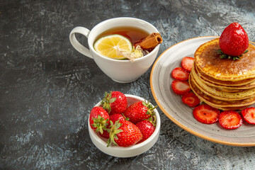 front view yummy pancakes with tea and fruits on light background fruit cake sweet