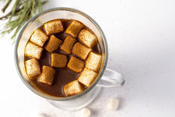 Hot coffe with marshmallows in transparent tall glass, isolated on white background.