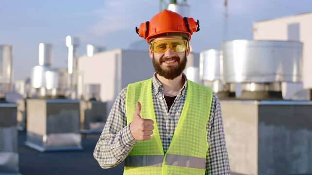 Portrait of a smiling large engineer man posing in front of the camera showing a big like and wearing construction eyeglasses. Shot on ARRI Alexa