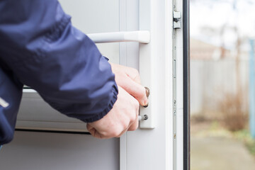 Handyman installing lock in plastic front door. Checking the door for operability. - 400031565