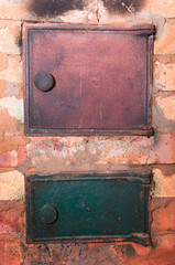 Old shabby and rusty metal door of brick furnace in country house