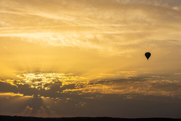 hot air balloon in the sky with orange sunrise clouds