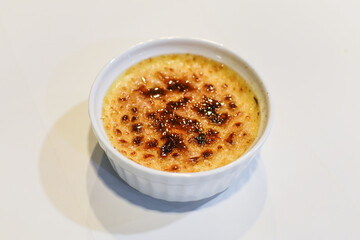 Caramelized crème brulee in a white cup
